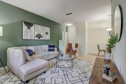 spacious living room with green accent wall and white couch